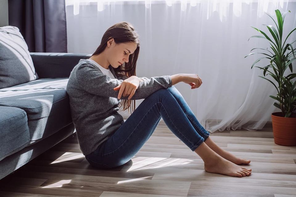 Depressed sad worried young brunette woman sitting on floor alone troubled with loneliness, upset about solitude mental problem, think of abortion regret bad mistake, breakup or divorce concept